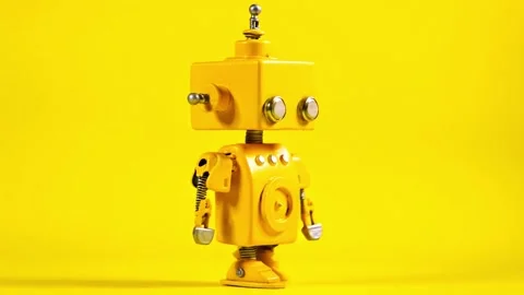 Yellow robot walking on a yellow background. Stock Footage 304513987