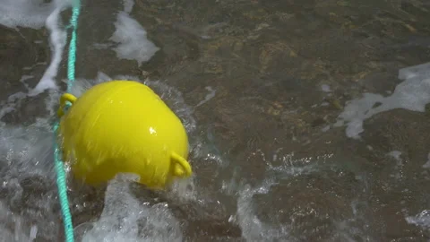 A yellow, round buoy floating on the surface of undulating water. Stock Footage 204150651
