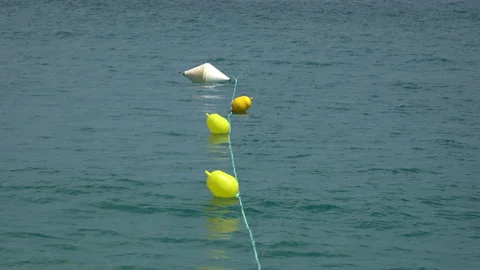 A yellow, round buoys floating on the surface of undulating water. Stock Footage 204145998