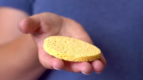 Yellow round sponge in a woman's hand 4K Stock Footage 156530050