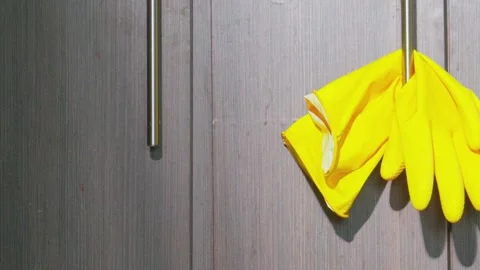 Yellow rubber gloves hanging on kitchen cabinet handle 動画素材 338305618