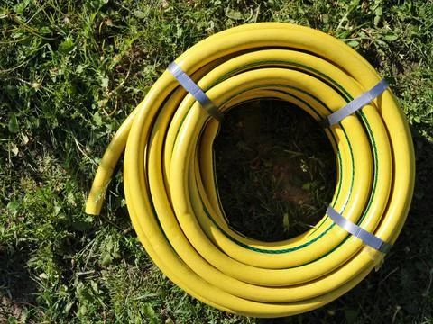 Yellow rubber new hose coiled into a ring Stock Photos