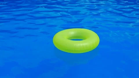 A yellow rubber ring floats on the surface of a blue pool Stock Footage 274064691