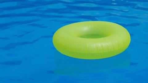 A yellow rubber ring floats on the surface of a blue pool Stock Footage 274064817