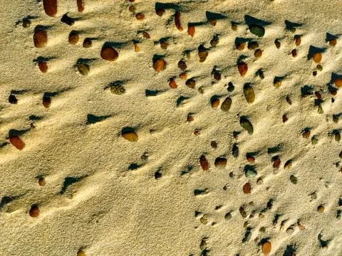 Yellow sand texture background sandy beach small stones on the beach top view Foto stock