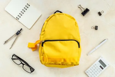 Yellow school backpack with student accessories. College and school concept Stock Photos