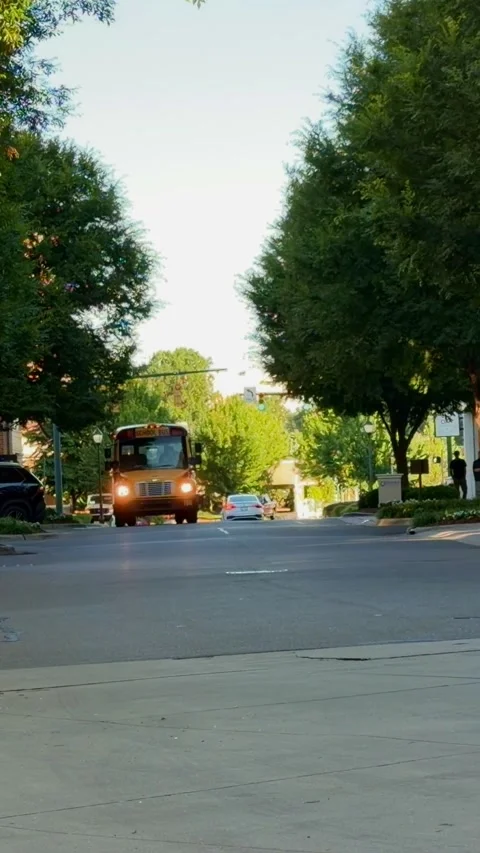 A yellow school bus drives down the street Video stock 337497867