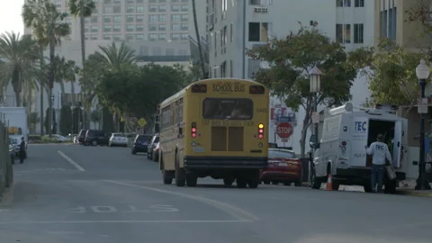 Yellow School Bus Driving Along Urban Street Vídeos de archivo 344609011