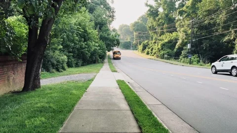 Yellow school bus driving down the road Stock Footage 243660413