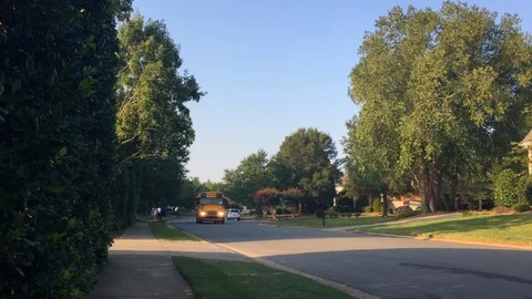Yellow school bus driving through a neighborhood Stock Footage 94390675