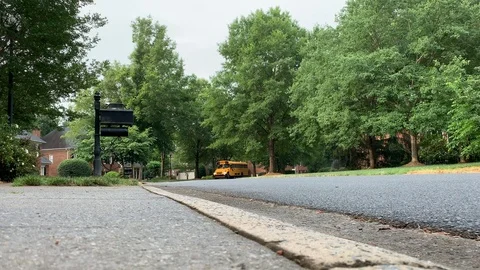 Yellow school bus driving through a neighborhood Video stock 109304927