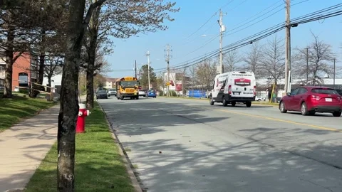 A yellow school bus rides down the street in Dartmouth, Canada. Stock Footage 277408090