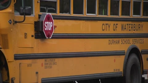 Yellow school bus stop light retracting and driving Stock Footage 304373543