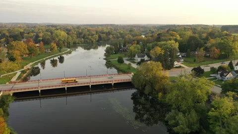 Yellow school bus with students inside driving down a city street Video stock 162806049