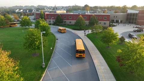 Yellow school buses driving in bus loop ... | Stock Video | Pond5