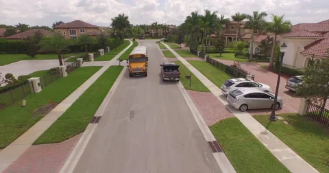 Yellow SchoolBus driving down a suburban street with nice clouds and blue ski 動画素材 55700730