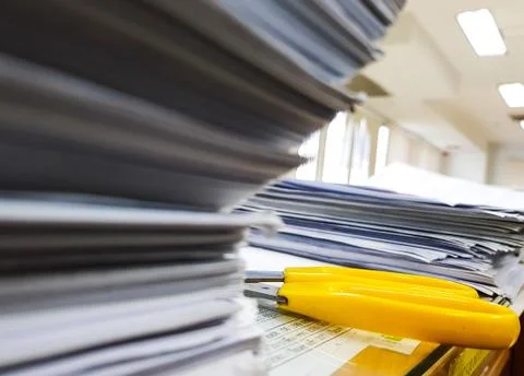 Yellow Scissors and Pile of documents on desk stack up high on Office backgro Foto stock