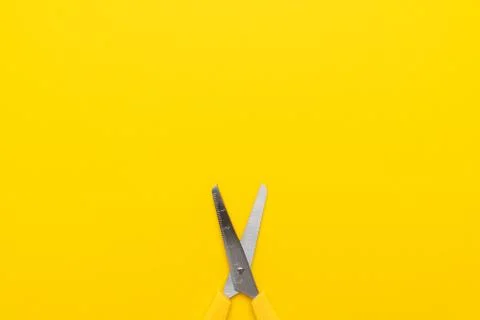 Yellow scissors on the yellow background with copy space Stock Photos