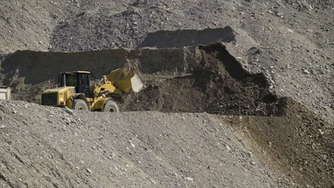 Yellow scraper excavator in a stone quarry for sand mining Видео 247282360