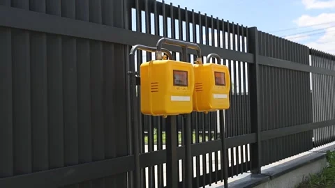Yellow security lockboxes hanging on dark metal fence beside urban property Stock Footage 337937581