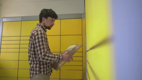 Yellow self-service postal terminal. Sending parcel. Parcel pick up point Stock Footage 285361646