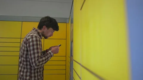 Yellow self-service postal terminal. Sending parcel. Parcel pick up point Stock Footage 329428146