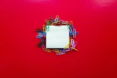 Yellow sheet of paper for notes and paper clip Foto stock