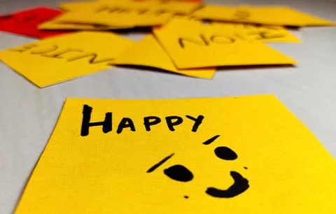 Yellow short note paper with written words happy Stock Photos