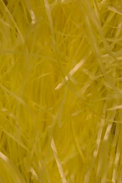 Yellow shredded plastic fake Easter grass background Stock Photos