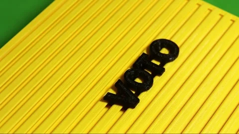 Yellow sign with a green background with the phrase vote Stock Footage 345540658