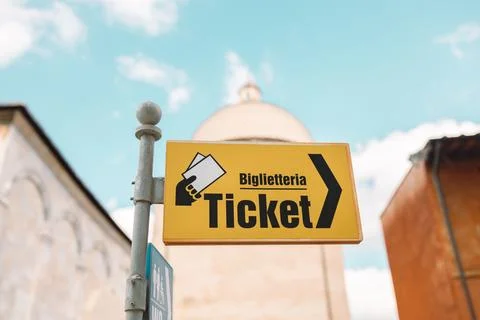 Yellow sign pointer and arrow directing to tickets in the streets of Pisa, Italy Stock Photos