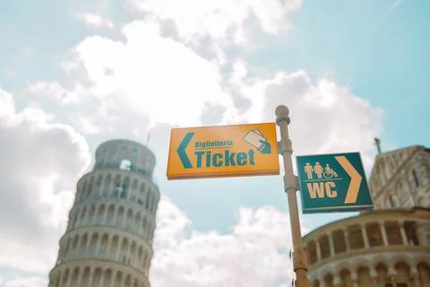 Yellow sign pointer and arrow directing to tickets in the streets of Pisa, Italy Stock Photos