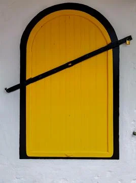 Yellow simplistic closed window in the old medina of Asilah Stock Photos