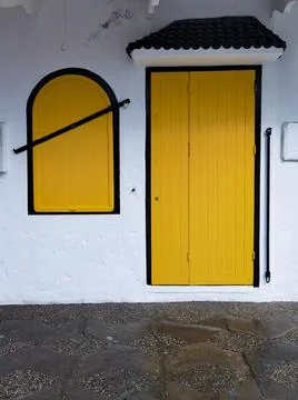 Yellow simplistic window with a yellow door in the old medina of Asilah Stock Photos