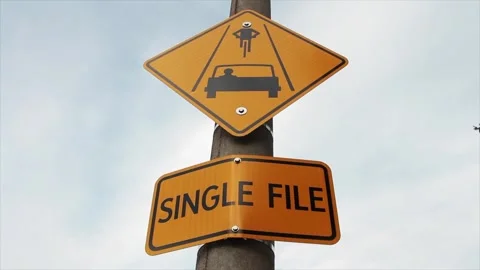 Yellow single file caption rectangle sign with yellow diamond sign above it Stock-Footage 246611579