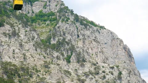 The yellow ski elevator descends from the mountains Stock Footage 245501096