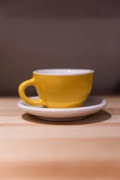 Yellow small cup on the table. Image contains excessive noise Stock Photos