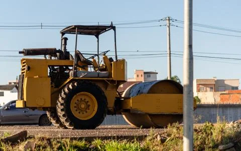 Yellow Smooth or Single-drum roller parked on a highway Stock Photos