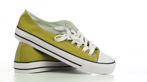 Yellow sneakers revolve on a white background Stock Footage 50003020