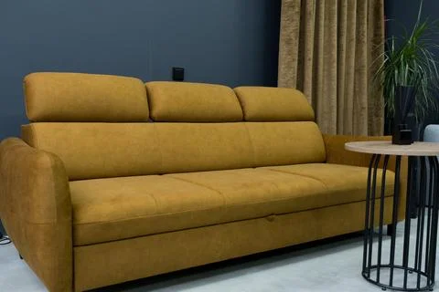 Yellow soft sofa in the interior against a gray wall Stock Photos