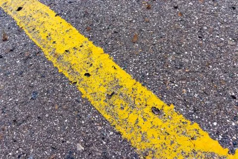Yellow solid line, grunge single road marking on asphalt, background with copy Foto stock