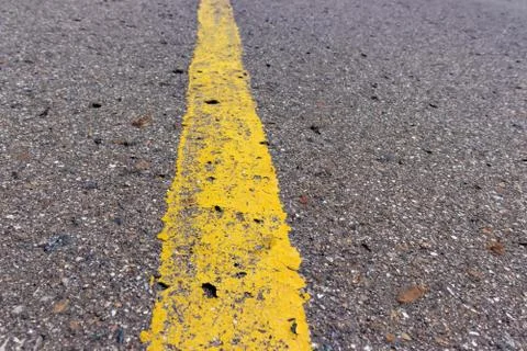 Yellow solid line, grunge single road marking on asphalt, background with cop Foto stock