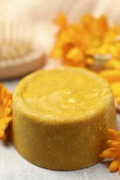 Yellow solid shampoo bar and flowers on light table, closeup. Hair care 写真素材