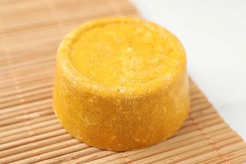 Yellow solid shampoo bar on light table, closeup Stock Photos