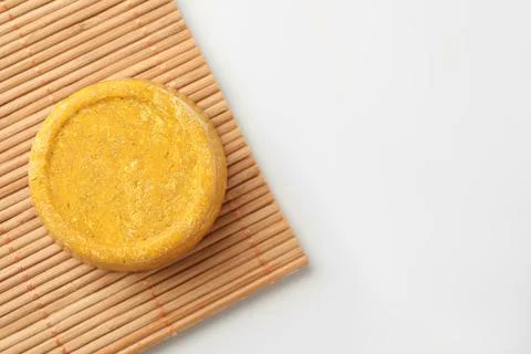 Yellow solid shampoo bar on light table, top view. Space for text 写真素材