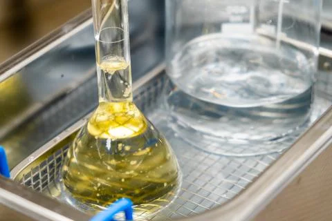 Yellow solution in the flask and beaker for dissolving or extraction into Stock Photos