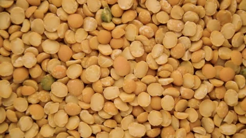 Yellow split peas rotate on the surface. Top view food background Stock Footage 142034145