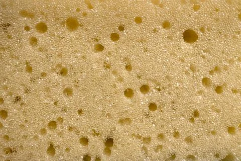 Yellow sponge perforated texture background Stock Photos