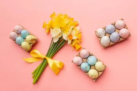 Yellow spring bouquet and easter colorful eggs on pink background Stock Photos
