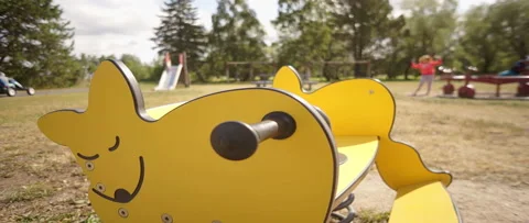 Yellow spring rider on a playground Stock Footage 165358352